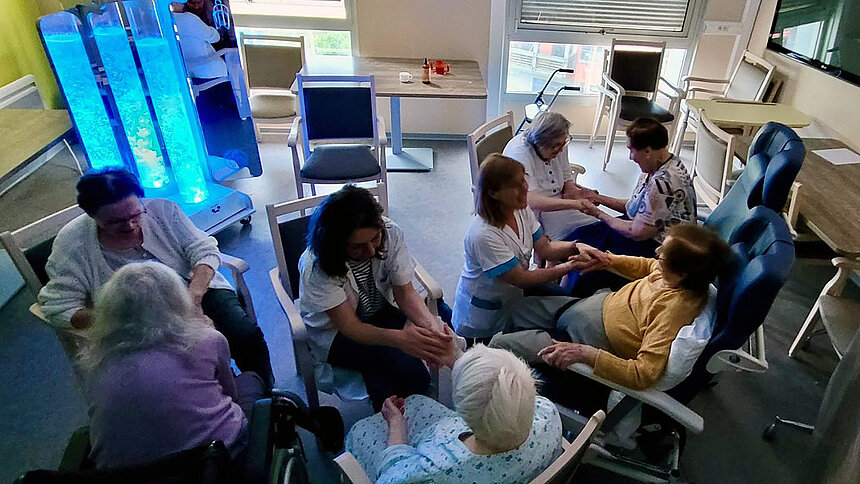 Des professionnelles Filieris massent les mains des résidents.