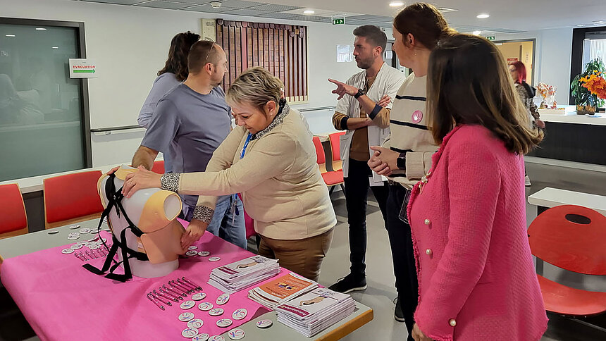 Une femme touche le buste de palpation sous le regard du personnel Filieris.