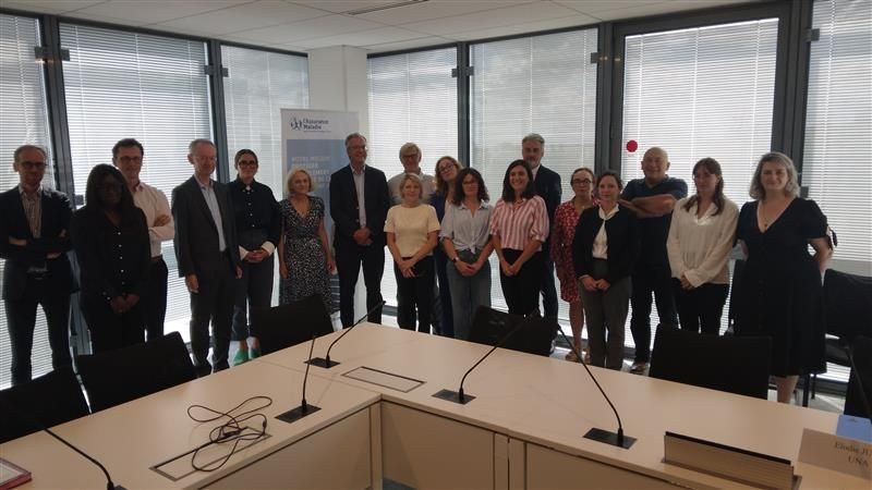 un groupe de personnes dans une salle de réunion après la signature de l'accord